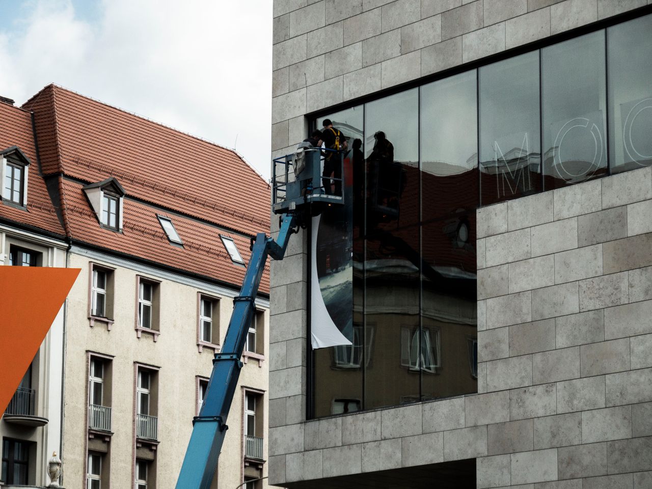 Crafting Captivating Headlines: Your awesome post title goes here Workers on a lift install a large banner on a modern building in Wrocław, Poland.